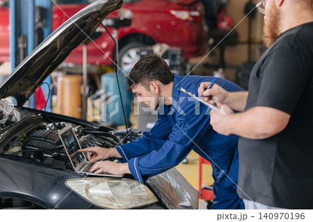 Car engineer technician worker, Technician team use laptop computer for tuning ECU with software. 140970196