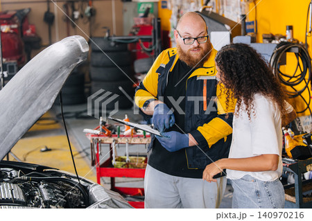 Car engine service in garage workshop, Customer worry talking with mechanic man. Car engine service in garage workshop, Customer worry talking with mechanic man. 140970216
