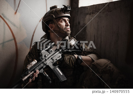 Military soldier Hide in a shelter with assault rifle, tactical operator in urban combat mission Military soldier Hide in a shelter with assault rifle, tactical operator in urban combat mission 140970555
