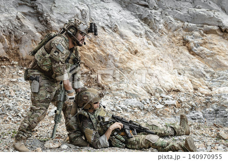Marine Special Forces commando providing soldier injured evacuation assistance during military operation 140970955