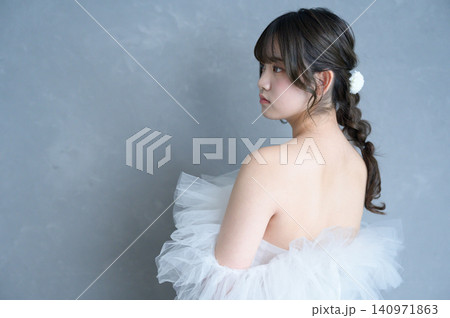 グレー背景で振り返るウェディングドレスを着た日本人女性 グレー背景で振り返るウェディングドレスを着た日本人女性 140971863