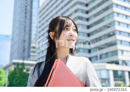 ビル街でバインダーを持つ日本人女性 140972163