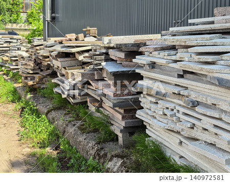 Stacked granite stone slabs at warehouse with mixed colors and sizes 140972581