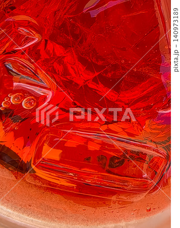 Abstract macro of red fizzy drink with ice cubes in glass Abstract macro of red fizzy drink with ice cubes in glass 140973189