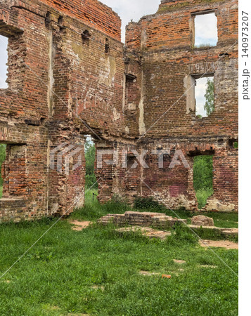 Ruined brick mansion walls with empty windows and green grass courtyard Ruined brick mansion walls with empty windows and green grass courtyard 140973207