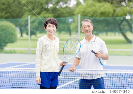 笑顔で並ぶテニスを楽しむシニア夫婦・屋外テニスコート 140974340
