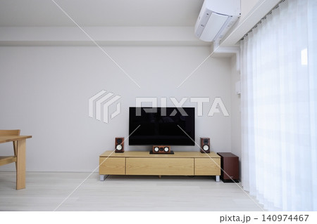 木製テレビボードに設置された大型テレビとホームシアターシステム 140974467