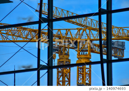 Crane truck working in construction site with sky background. Crane against sky. Crane, Construction background, construction equipment crane background. Crane truck working in construction site with sky background. Crane against sky. Crane, Construction background, construction equipment crane background. 140974693
