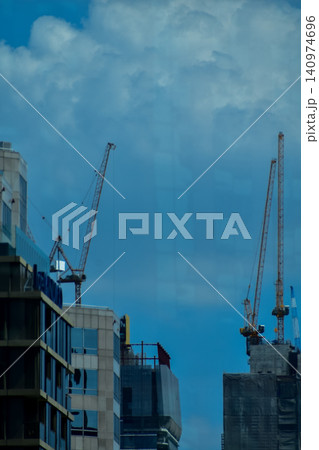 Crane truck working in construction site with sky background. Crane against sky. Crane, Construction background, construction equipment crane background. Crane truck working in construction site with sky background. Crane against sky. Crane, Construction background, construction equipment crane background. 140974696