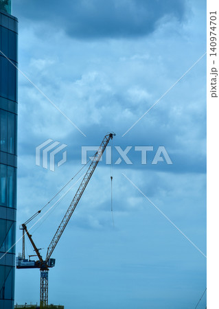 Crane truck working in construction site with sky background. Crane against sky. Crane, Construction background, construction equipment crane background. Crane truck working in construction site with sky background. Crane against sky. Crane, Construction background, construction equipment crane background. 140974701