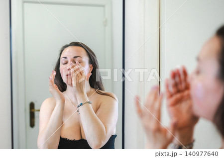 Beauty Portrait of Woman Applying Face Cream Beauty Portrait of Woman Applying Face Cream 140977640