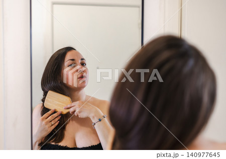 Woman Combing Hair - Daily Beauty Routine Woman Combing Hair - Daily Beauty Routine 140977645