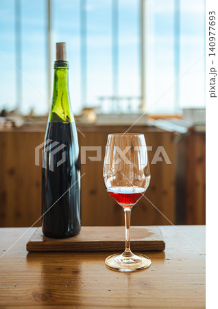 Bottle and Red Wine Glass on Table Coastal Tasting Room Bottle and Red Wine Glass on Table Coastal Tasting Room 140977693