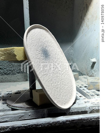 Ceramic plate is being carefully shaped and crafted in a pottery studio, illustrating the art of clay production and design 140978056