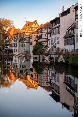Sunlit Heritage Facades Reflected in Canal Warm Tones 140978307
