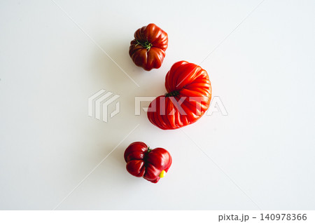 Heart shaped tomato pair on white surface Heart shaped tomato pair on white surface 140978366