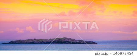 Island on the horizon. Rocks in the sea. Beautiful rocky sea landscape in evening. Wild nature Norway, seascape. Gradient color Island on the horizon. Rocks in the sea. Beautiful rocky sea landscape in evening. Wild nature Norway, seascape. Gradient color 140978454