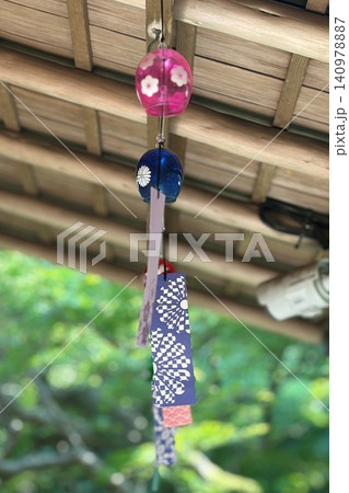 木造のひさしの下に連なる色鮮やかな江戸風鈴と新緑の美しいボケ味 140978887