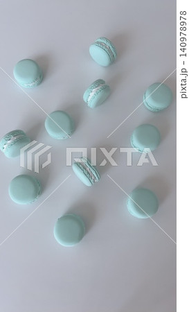 白い背景に散りばめられたアクアブルーのマカロンの俯瞰 白い背景に散りばめられたアクアブルーのマカロンの俯瞰 140978978