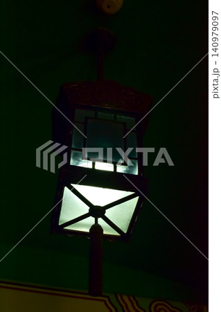 Close-up of the Chinese classical lamp hanging on the ceiling at night. Light bulb. Interior design, decoration. Lighting equipment. Close-up of the Chinese classical lamp hanging on the ceiling at night. Light bulb. Interior design, decoration. Lighting equipment. 140979097