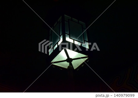 Close-up of the Chinese classical lamp hanging on the ceiling at night. Light bulb. Interior design, decoration. Lighting equipment. 140979099