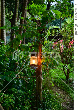 Beautiful colorful illuminated lamp in the garden. Retro style lantern outdoor. Antique lantern. Nature concept. 140979123