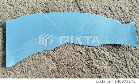 Torn Blue Paper Strip on Rough Gray Concrete Texture Background Torn Blue Paper Strip on Rough Gray Concrete Texture Background 140979175