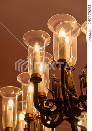 Gold vintager chandelier light in a room for interior decoration. Chandelier Candlestick. Crystal chandelier, intricately designed golden chandelier with radiant bulbs illuminating. Gold vintager chandelier light in a room for interior decoration. Chandelier Candlestick. Crystal chandelier, intricately designed golden chandelier with radiant bulbs illuminating. 140979291