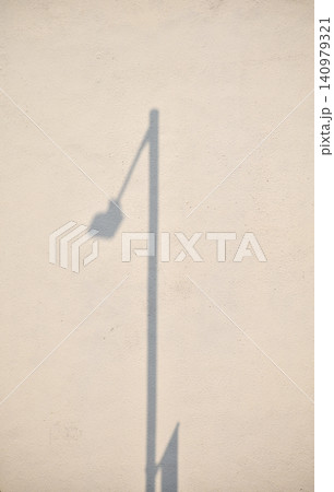 The shadow of the lamppost on the ground. Lamppost in the street. Streetlight in silhouette. Abstract background. Lamppost concept. 140979321