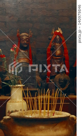 Rising incense smoke in an altar for ancestor worship decorated in reds during the Lunar New Year in Man Mo Temple in Shen wang, Hong Kong Rising incense smoke in an altar for ancestor worship decorated in reds during the Lunar New Year in Man Mo Temple in Shen wang, Hong Kong 140979846