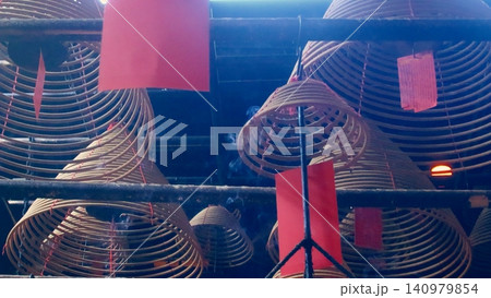 Low angle view of smoke emanating from spiral incense coils with red tags hung from the ceiling of Man Mo Temple, creating a serene sacred atmosphere. Sheung Wan, Hong Kong 140979854