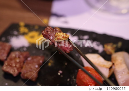 Sizzling Beef with Sauce on Chopsticks Sizzling Beef with Sauce on Chopsticks 140980035