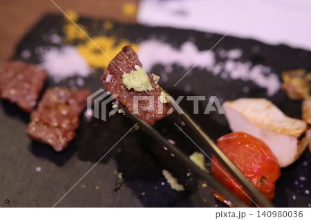 Gourmet Meat with Garlic Garnish on Slate Plate 140980036