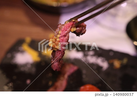 Grilled Steak with Garlic Sauce on Tongs 140980037