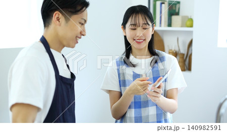 キッチン　スマホでレシピを考える男女のイメージ 140982591