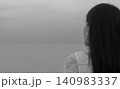 Back view of a thoughtful woman standing in dense fog, expressing solitude, mindfulness, emotional reflection, minimal monochrome lifestyle, peaceful nature, wellness, and quiet contemplation. 140983337