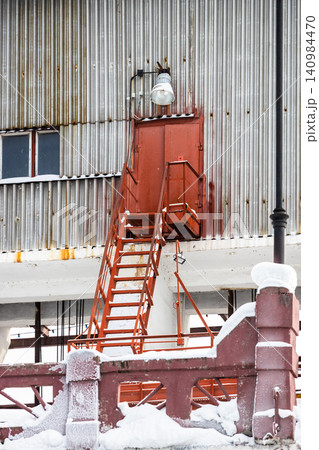 red stairs to tin wall of factory workshop red stairs to tin wall of factory workshop 140984470