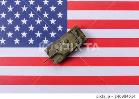 A tank on the US flag as a conceptual backdrop representing defense and preparation against attack A tank on the US flag as a conceptual backdrop representing defense and preparation against attack 140984614