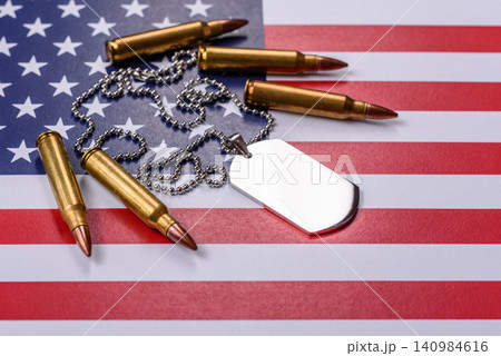 A dog tag on the US flag, serving as a conceptual backdrop representing defense 140984616