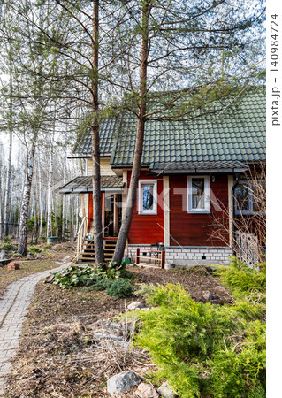 pine trees and simple country house on March day 140984724