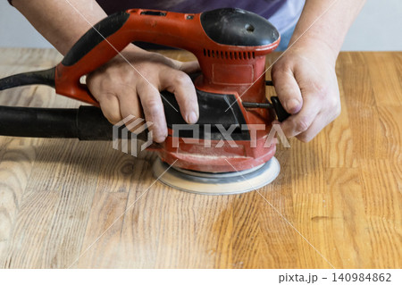 repairman polishes table using polishing machine 140984862