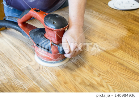 man polishes surface of table by polishing machine man polishes surface of table by polishing machine 140984936