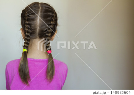 Close up rear- vew portrait of a cute little girl with funny pigtails on white background. Fashion and happy childhood. Close up rear- vew portrait of a cute little girl with funny pigtails on white background. Fashion and happy childhood. 140985604
