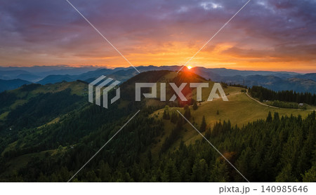 Amazing mountain landscape. Dark spruce woods illuminated with yellow setting sun. Bright colorful sunset in wild national park highlands Amazing mountain landscape. Dark spruce woods illuminated with yellow setting sun. Bright colorful sunset in wild national park highlands 140985646