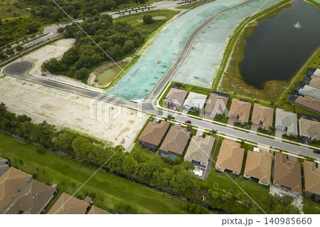 Real estate development with tightly located family houses under construction in Florida suburban area. Concept of growing american suburbs Real estate development with tightly located family houses under construction in Florida suburban area. Concept of growing american suburbs 140985660