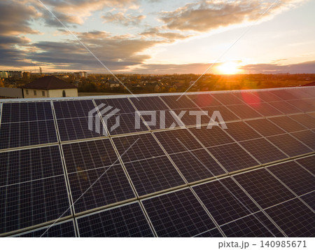 Ecological building with photovoltaic rooftop installation. Solar panels producing renewable electricity with zero carbon emissions. Ecological building with photovoltaic rooftop installation. Solar panels producing renewable electricity with zero carbon emissions. 140985671