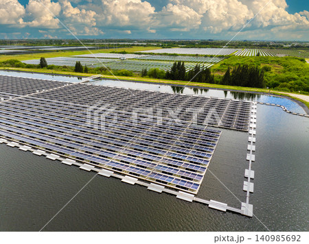 Efficient floating solar farm on pond water with rows of photovoltaic panels producing clean electricity. Concept of renewable energy generation using water-based infrastructure with no pollution 140985692