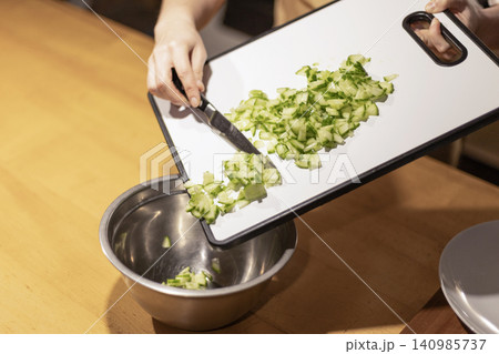 Chopped cucumber transferred from white cutting board into stain Chopped cucumber transferred from white cutting board into stain 140985737