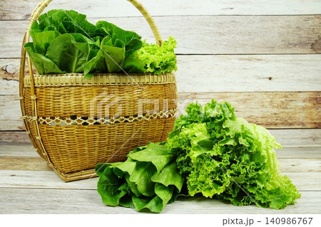 Fresh raw Iceberg, Romaine and Green Cos lettuces in bamboo basket on wooden background 140986767