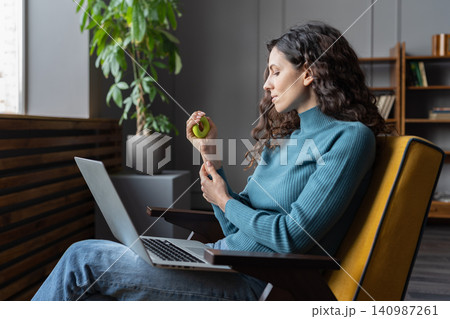 Hand and wrist exercises for office workers. Female employee using carpal expander to relieve stress Hand and wrist exercises for office workers. Female employee using carpal expander to relieve stress 140987261